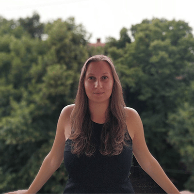 A standing woman with trees behind as a background