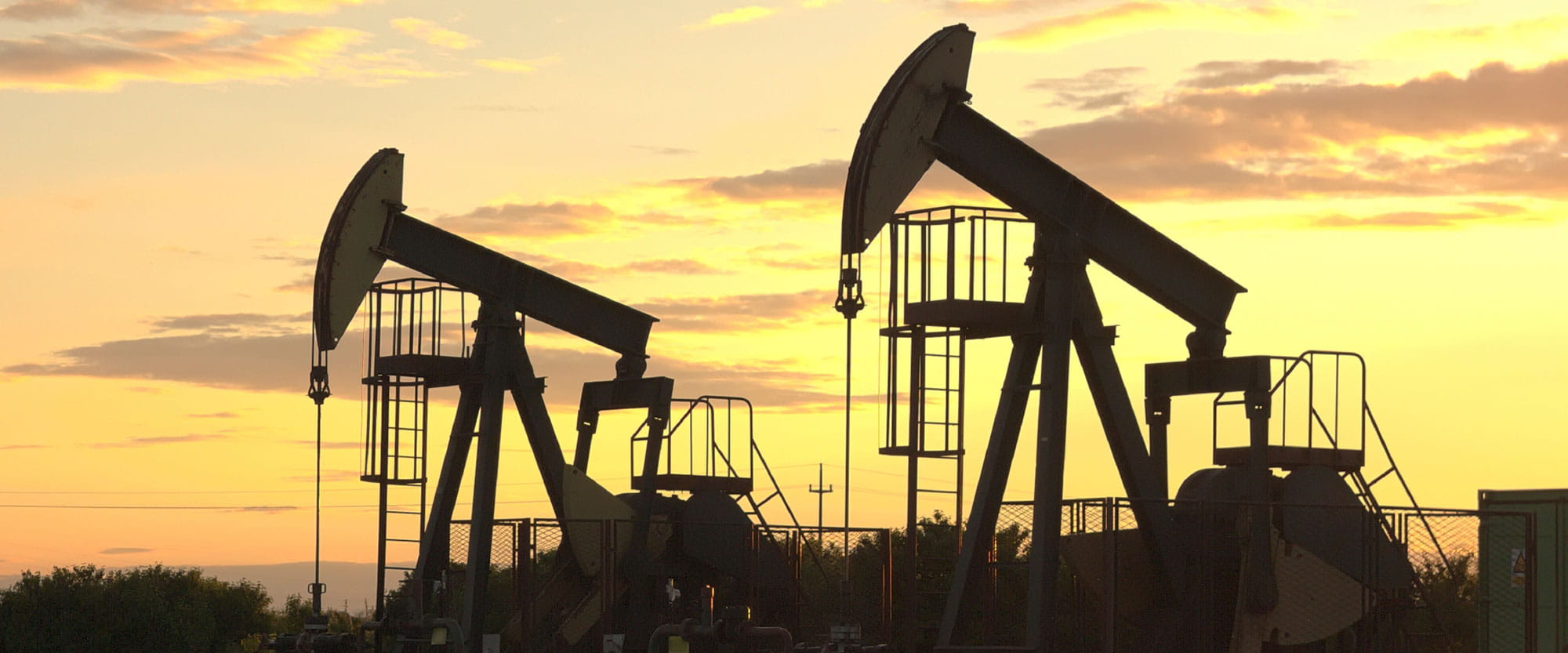 Nodding donkey oil wells in the declining evening sun