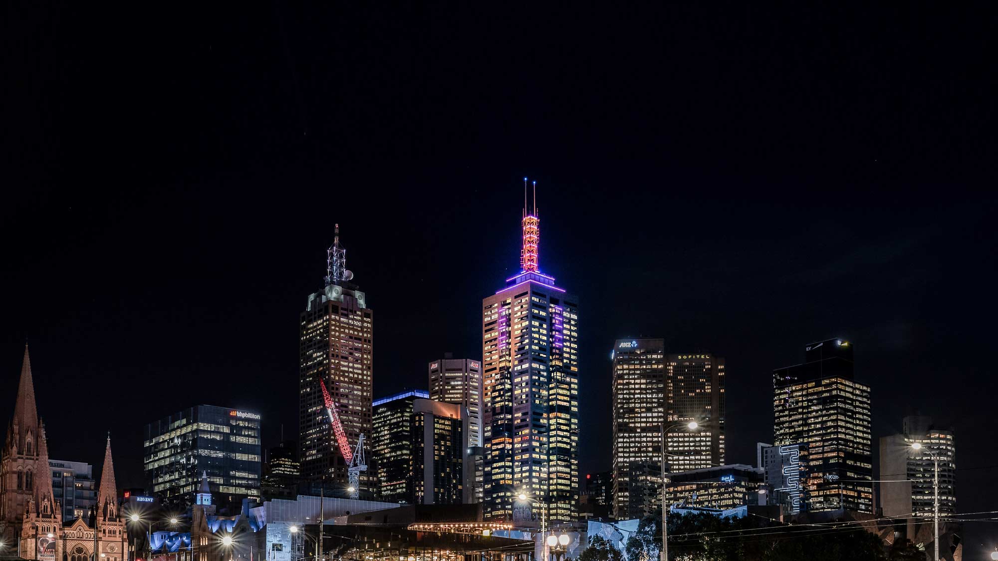 The spire of 101 Collins Street lighting up the Melbourne cityscape