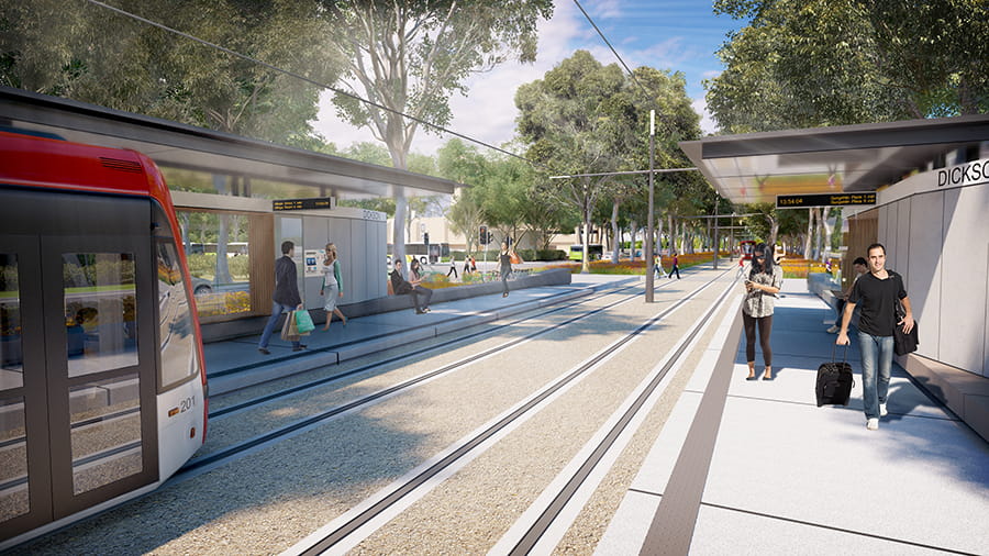 A light rail train pulls up to the Dickson stop. 