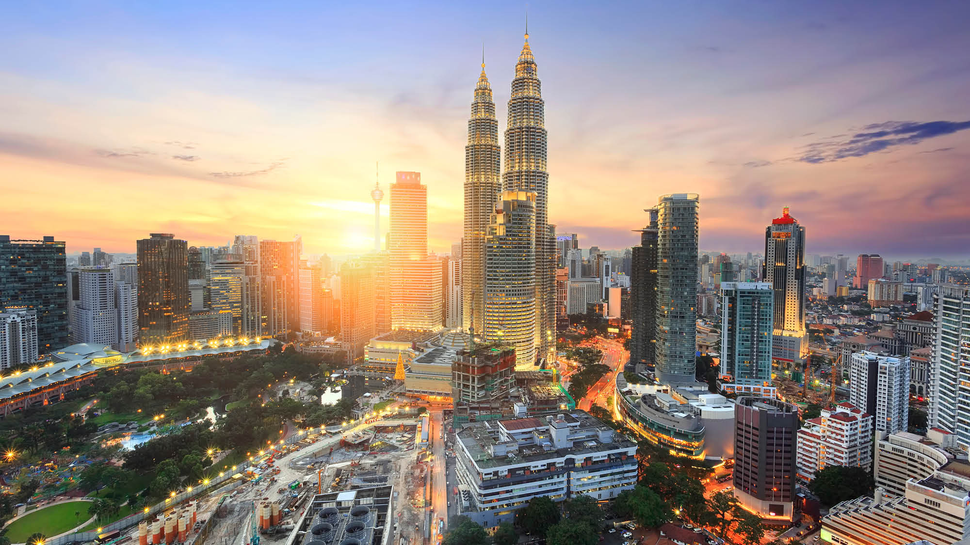 City skyline view at dusk over Kuala Lumpur Malaysia, showing the Petronas Towers in the centre
