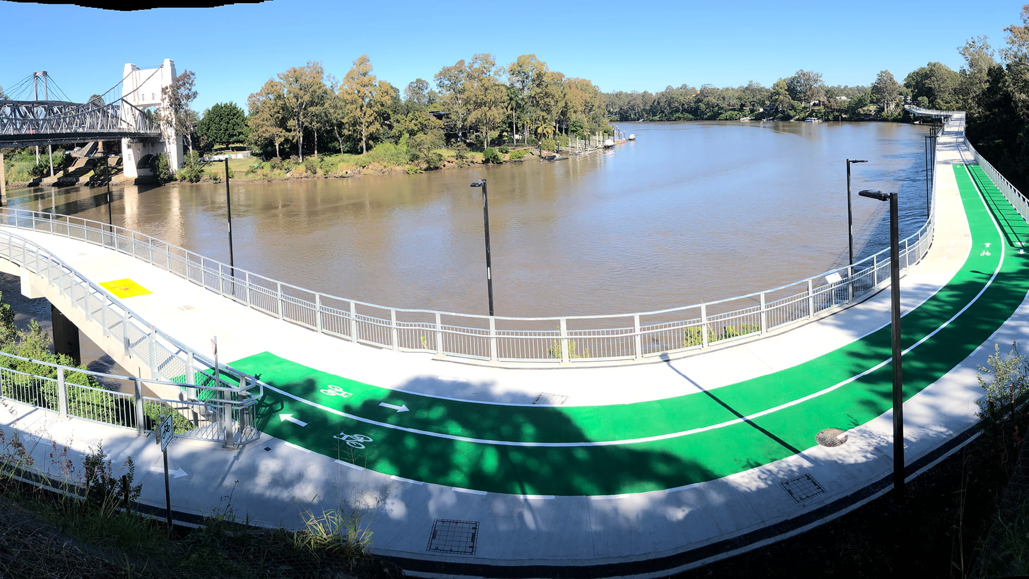 View of a curving river with boardwalk with pedestrian and cycle ways in daytime