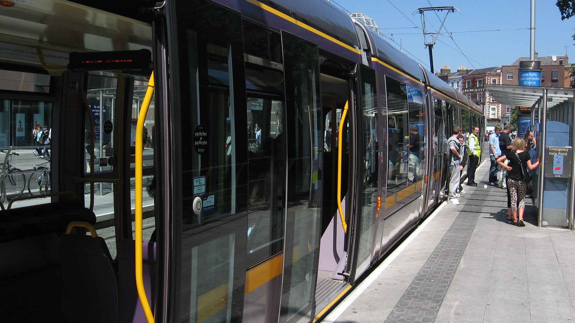 Luas tram alongside a platform with people.