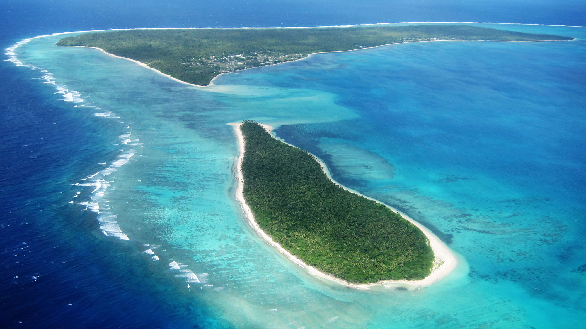 Aerial view of the islands of the Kingdom of Tonga on a bright, clear day