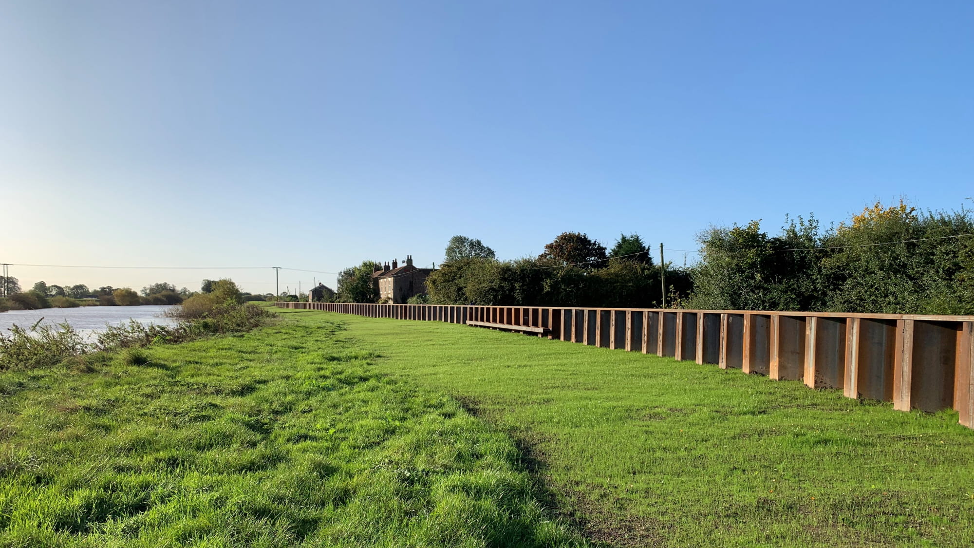 Yorkshire green field with the river and a house in the background