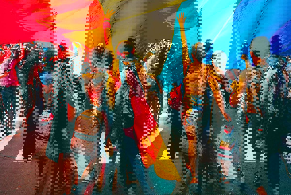 People marching under a rainbow flag