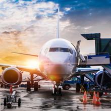 Airplane at an airport with a plane taking off in the background